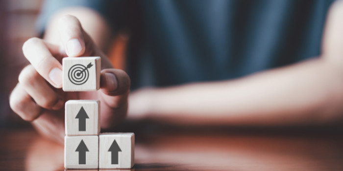 Man stacking cubes with arrows and placing a cube with target on top