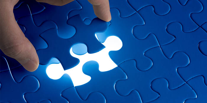 Person adds a missing piece to a puzzle