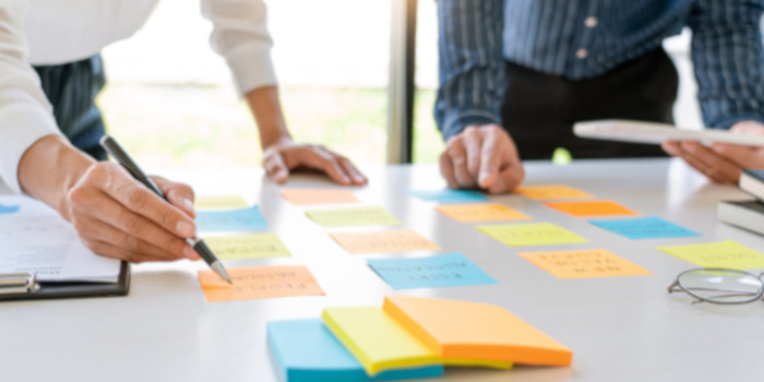 Two businessmen creating a plan with sticky notes