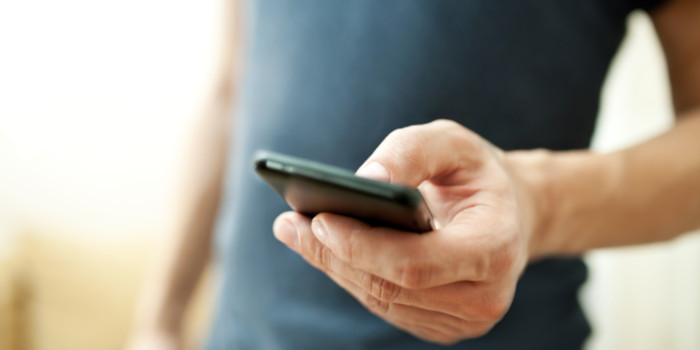 Close up photo of the hand of a man holding a smartphone