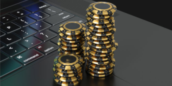 Poker chips stacked on top of a laptop, symbolizing online gambling