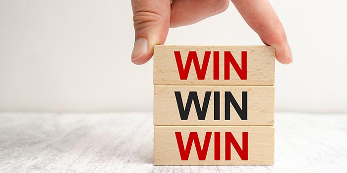 Person stacks wooden cubes with the word WIN written on them