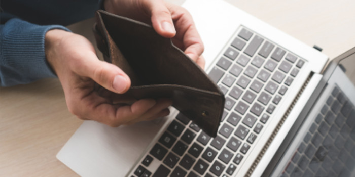 A man holding an opened empty wallet, symbolizing scam